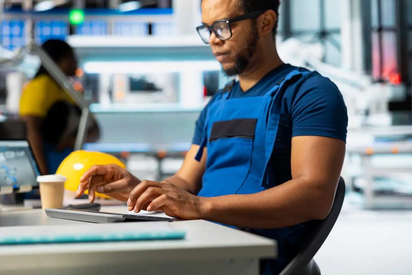 Técnico masculino usando una computadora para supervisar la línea de producción de paneles solares